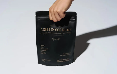 Cellular health supplements like Ageless Cocktail shown in sleek black packaging held by hand.