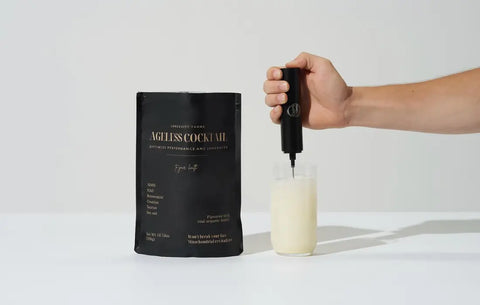 NMN vitality drink Ageless Cocktail being blended in a glass with handheld frother. 